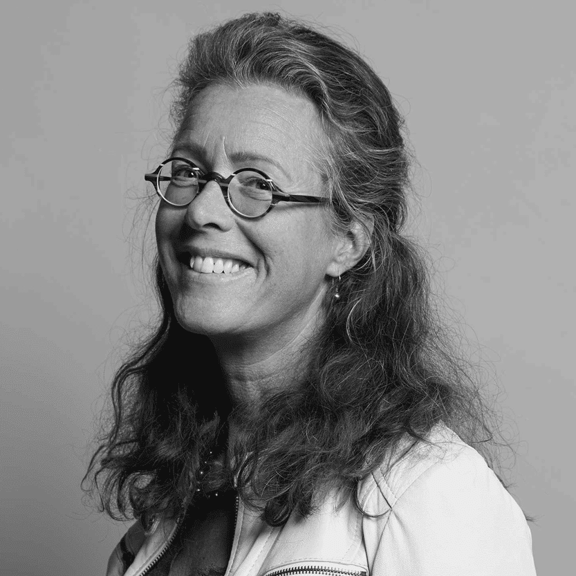 Portret van een lachende vrouw met bril, zwart-wit foto.