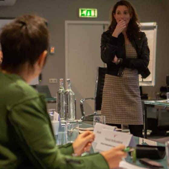 Vrouw die tijdens een workshop of training spreekt over onderbewuste impact.